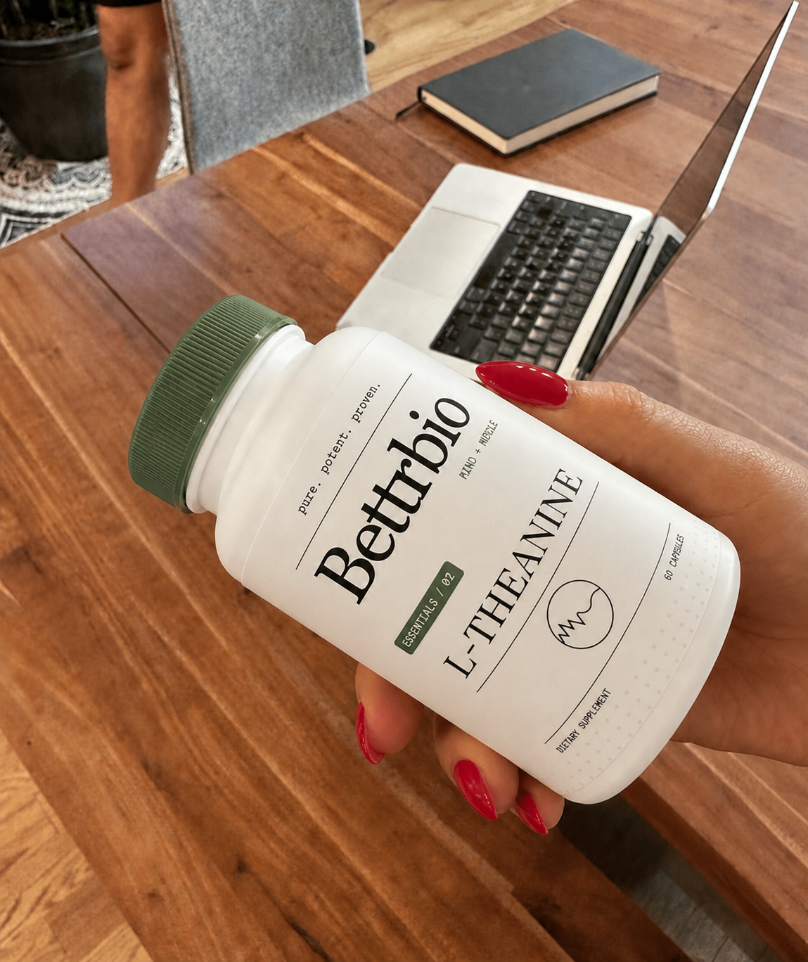 Customer holding Bettrbio L-Theanine beside a laptop